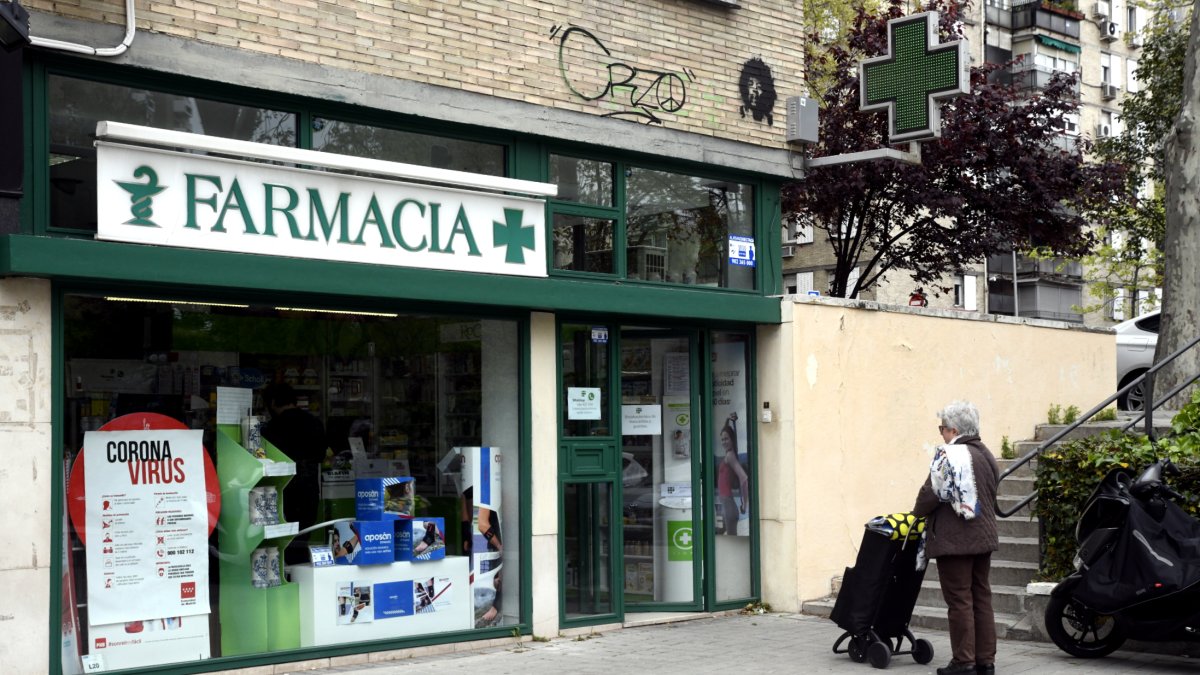 Una mujer espera a entrar a una farmacia durante el estado de alarma.