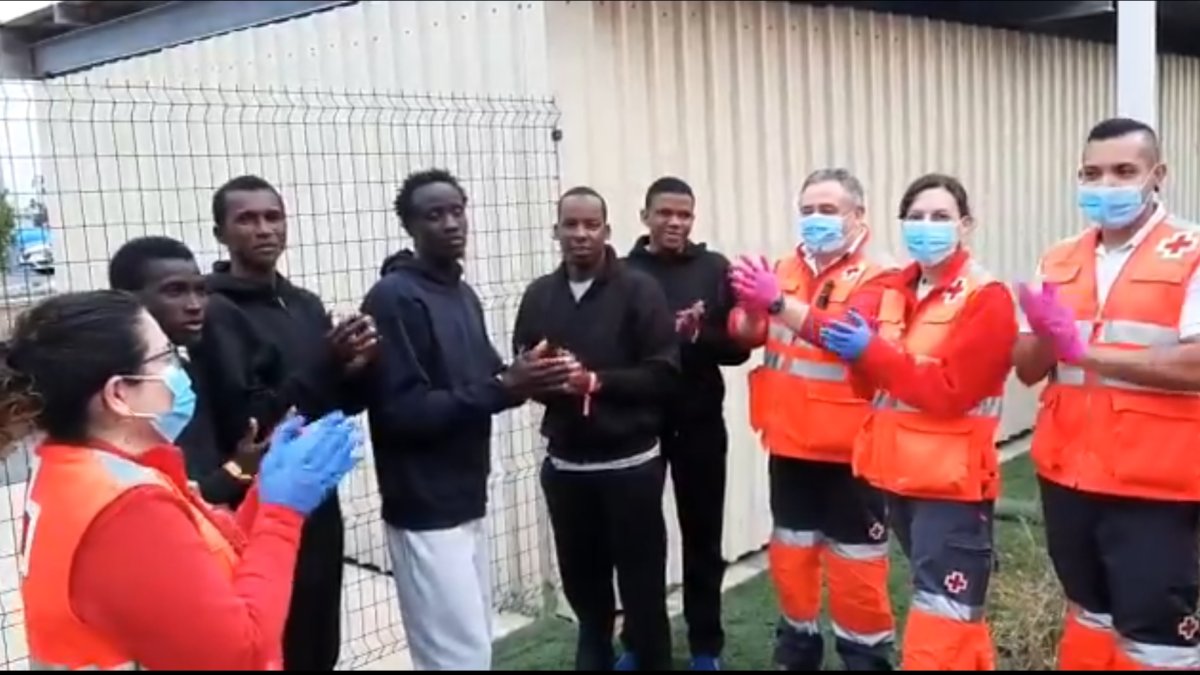 Aplausos a los sanitarios en el área de recepción de inmigrantes en el puerto