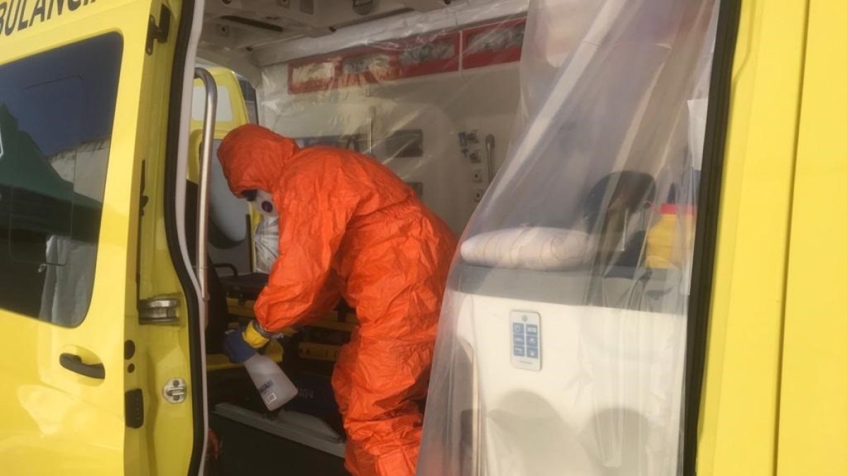 Un operario limpia y desinfecta una ambulancia.
