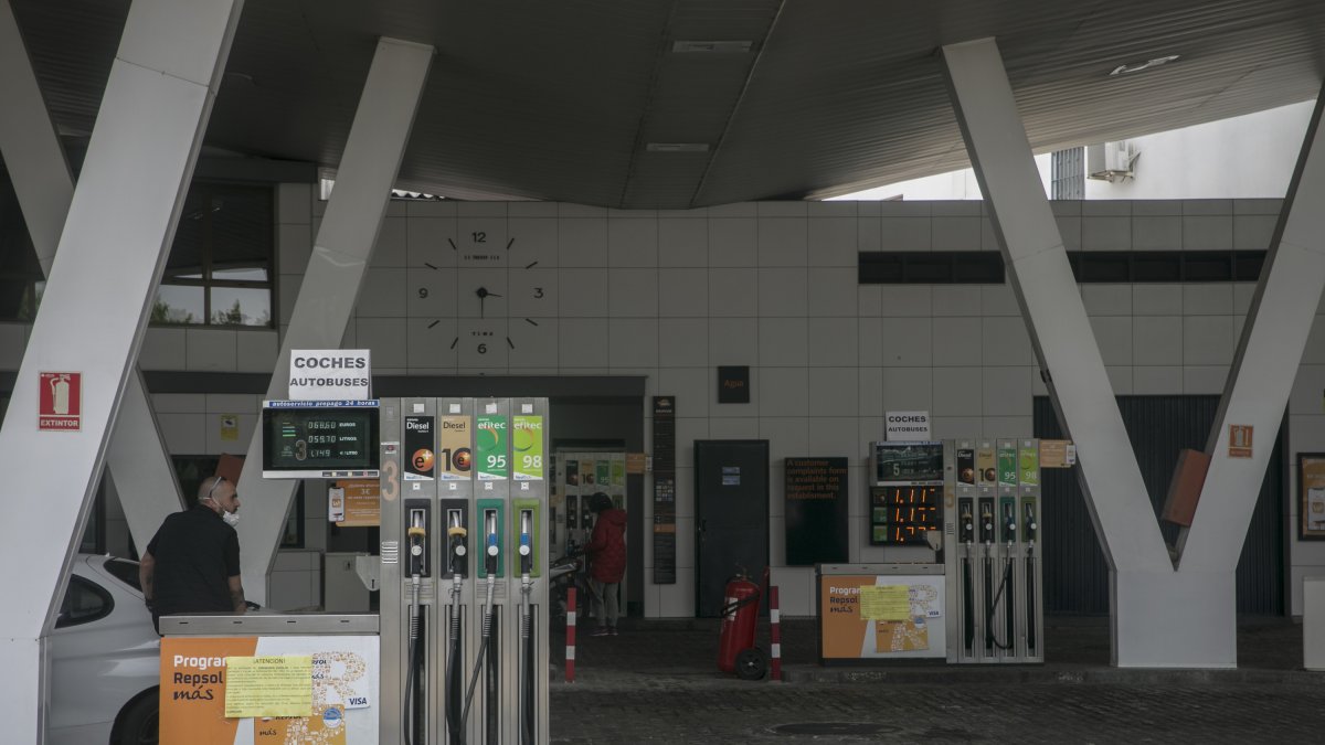 Dos personas repostando en una estación de servicio durante el estado de alarma.