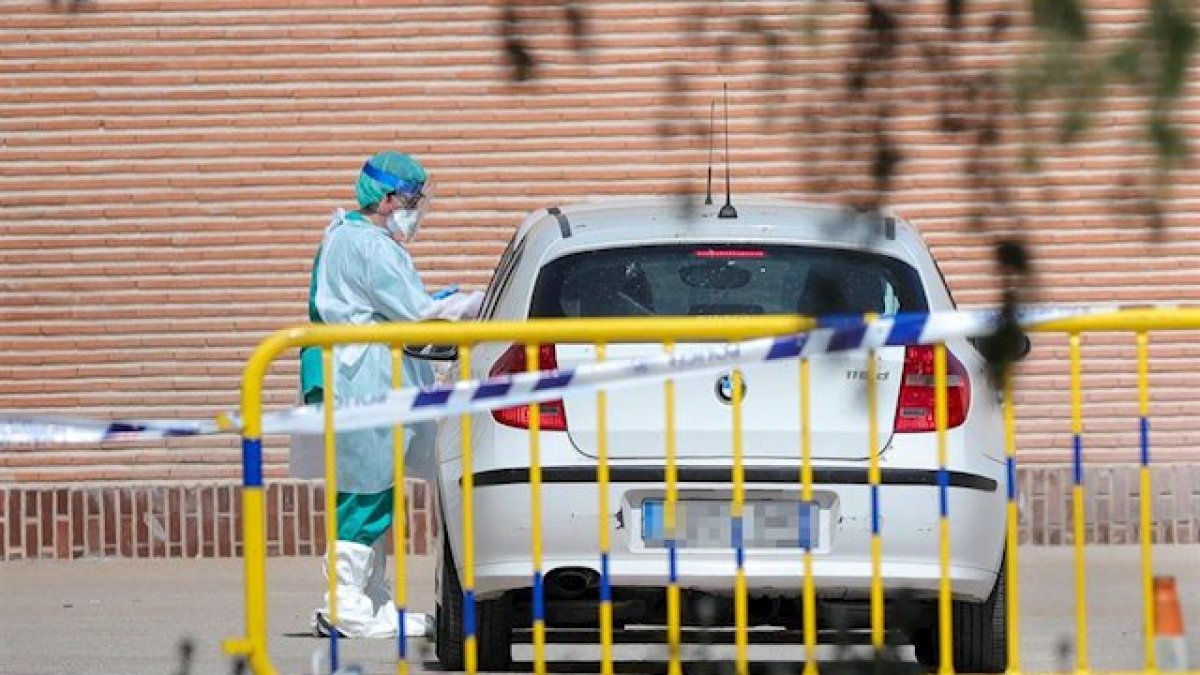 Un sanitario realizando un test rápido a un ciudadano desde su coche en la ciudad de Madrid.