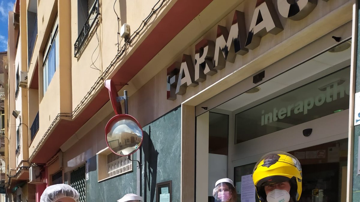 Personal de correos recibe una bolsa con medicinas de los farmacéuticos.