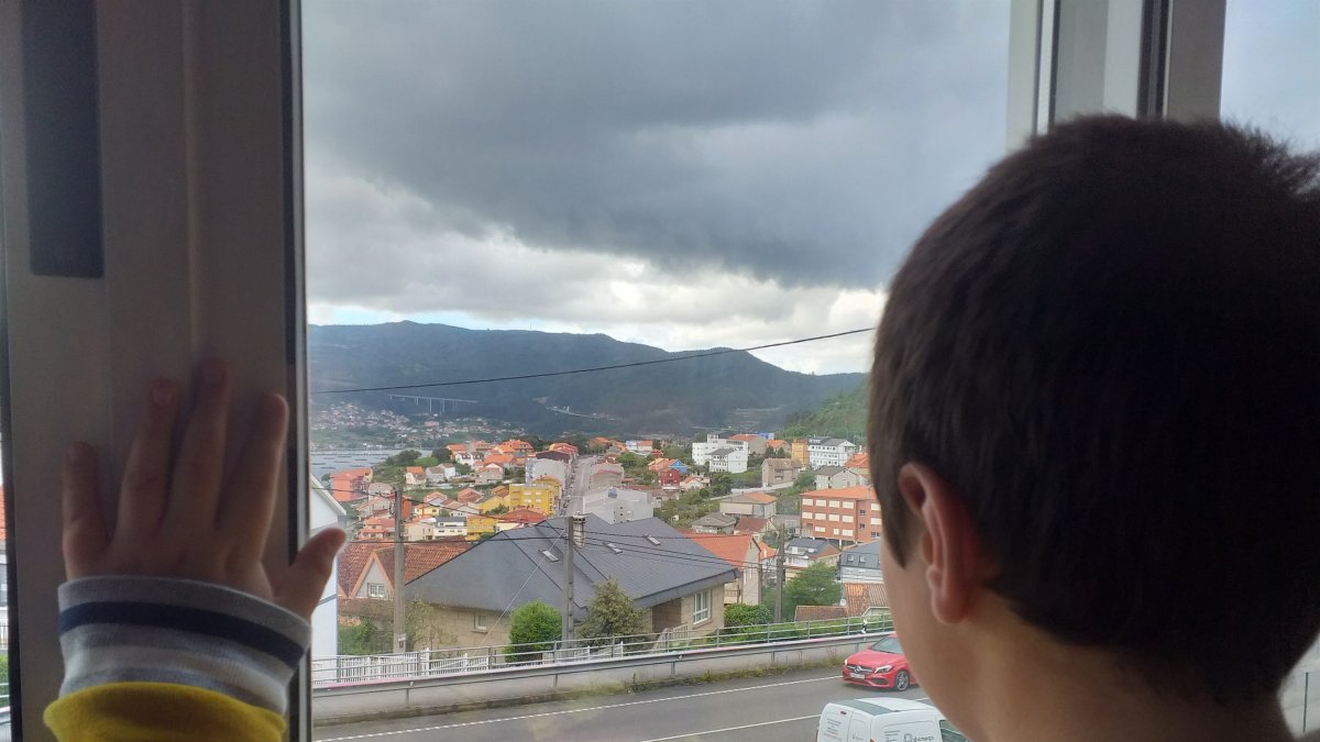 Un niño observa desde la ventana mientras se encuentra confinado.