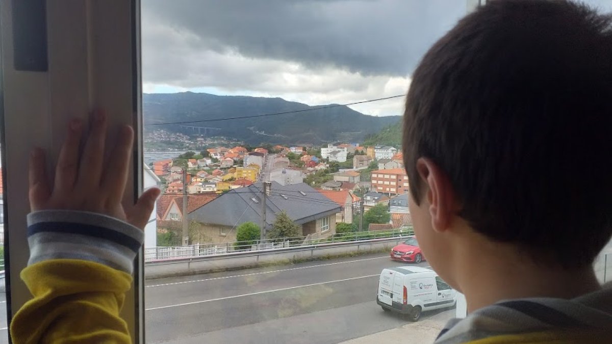 Un niño observa desde la ventana mientras se encuentra confinado.