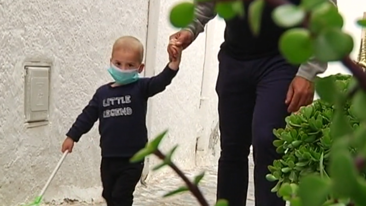 José María, con su mascarilla, de la mano de su padre (Fotos: Andalucía Directo).