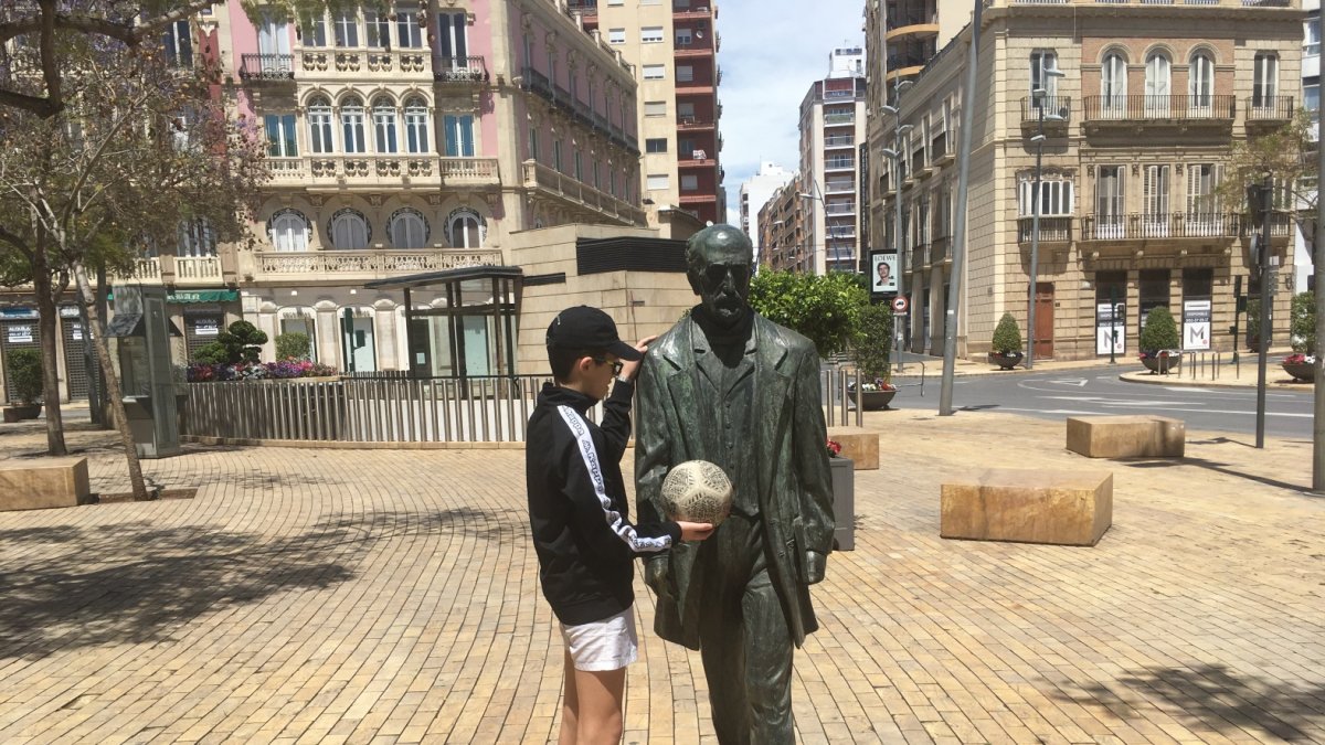 Un niño de Almería jugando el pasado domingo con la estatua de Nicolás Salmerón en la Puerta de Purchena, después de 40 días de confinamiento.