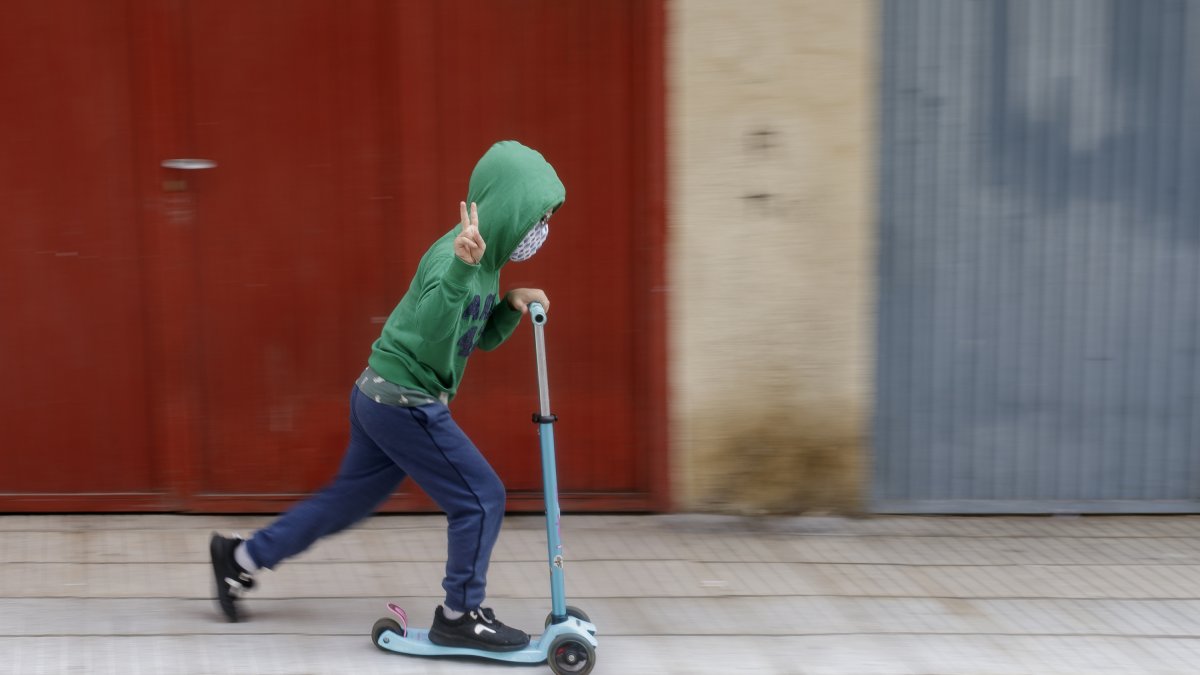 Un niño pasea en patinete en el primer día de salidas infantiles.