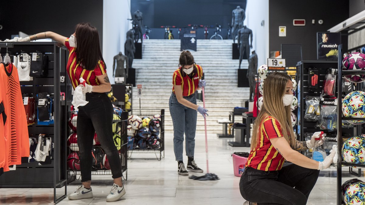 Las dependientas de una tienda de deportes de Roma se preparan antes de abrir.
