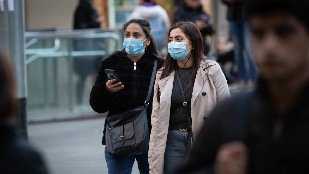 Dos mujeres por la calle con mascarillas.