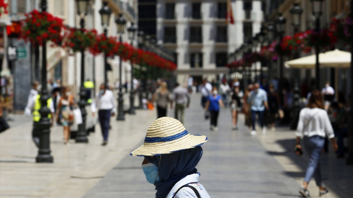 Una mujer con mascarilla en las calles de Málaga.
