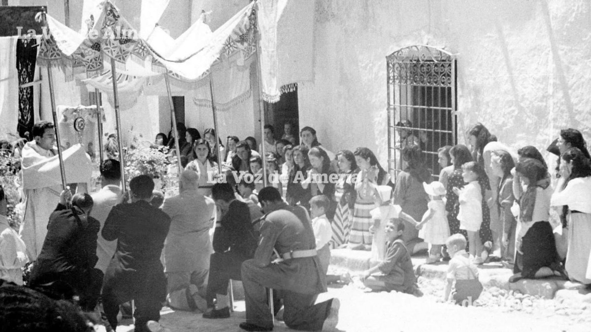 Procesión del Corpus en Turre en el año 1954. Los niños, arrodillados a su manera, asisten con extrañeza al ritual dirigido por don Manuel Sánchez.