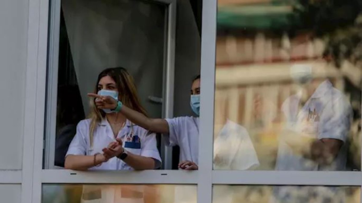Sanitarios aplauden desde una ventana del Hospital Fundación Jiménez Díaz.