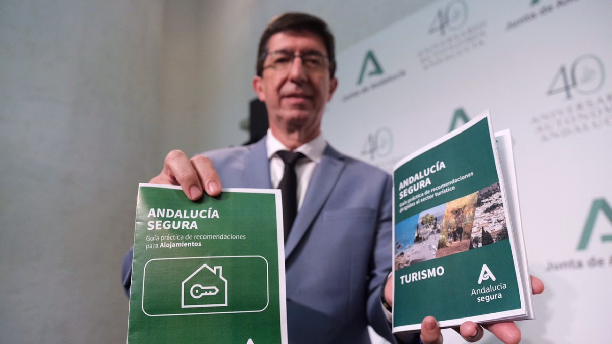 Juan Marín con folletos sobre el distintivo.