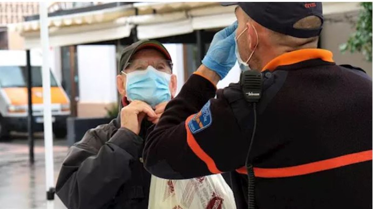Un hombre recibe indicaciones sobre cómo colocarse la mascarilla, en la estación intermodal de Palma.