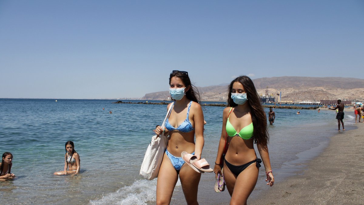 Las almerienses Ana y Aroa paseando por la orilla del mar y con mascarilla.