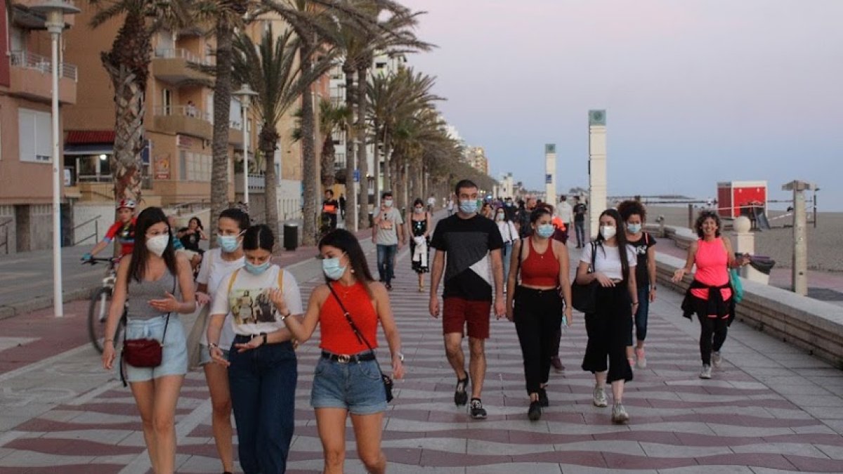 El paseo marítimo de la capital se llena de viandantes con mascarilla.