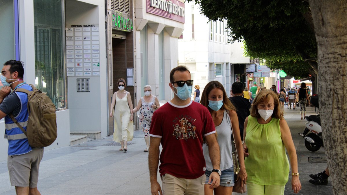 Almerienses circulan por la calle con la mascarilla obligatoria.