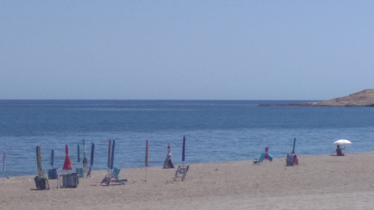 Sombrillas y sillas colocadas en primera línea de playa para reservar el espacio en las playas de Carboneras.