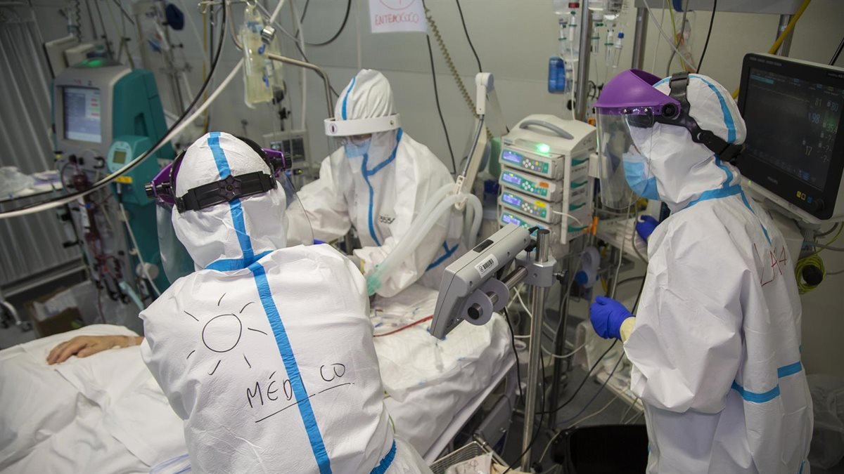 Médicos con EPI tratan a un paciente.