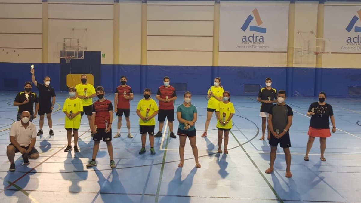 Los ganadores con sus trofeos en el centro de la pista.