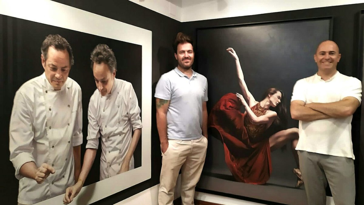 Los galeristas Javier y Trino Tortosa, junto a los óleos de Manuel Higueras. L