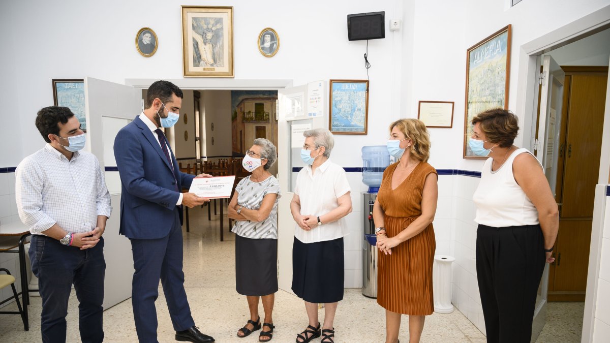 Entrega del cheque con lo obtenido en la primera remesa de venta de abanicos solidarios.