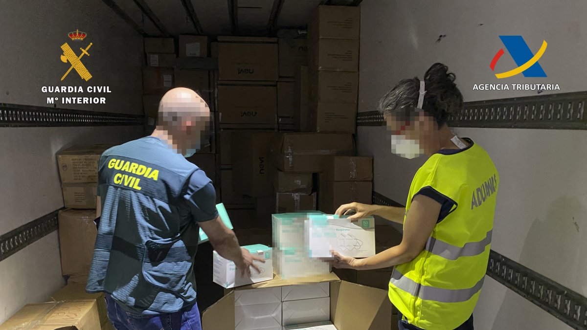 Agentes de la Guardia Civil con las mascarillas intervenidas.