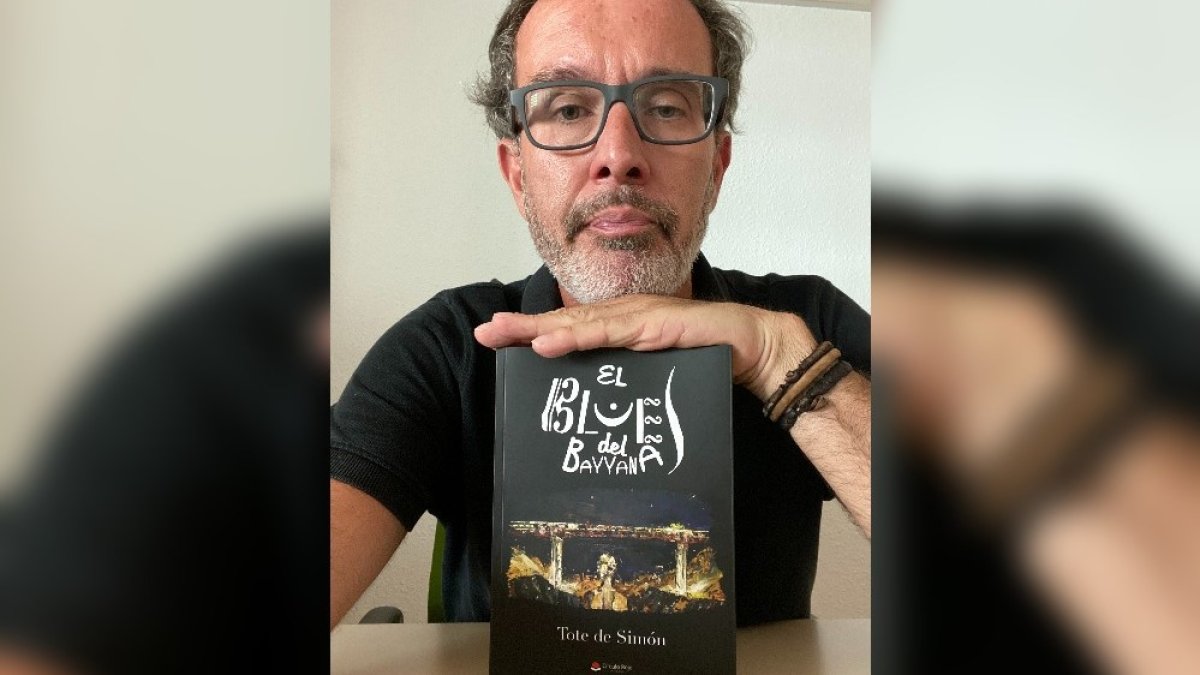 Tote de Simón con un ejemplar de su primer libro editado, El blues del Bayanna.