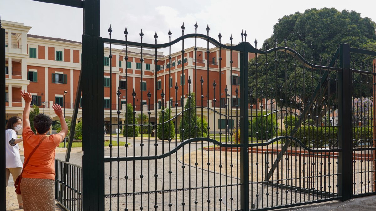 Una mujer saluda a un familiar en una residencia de Sevilla.