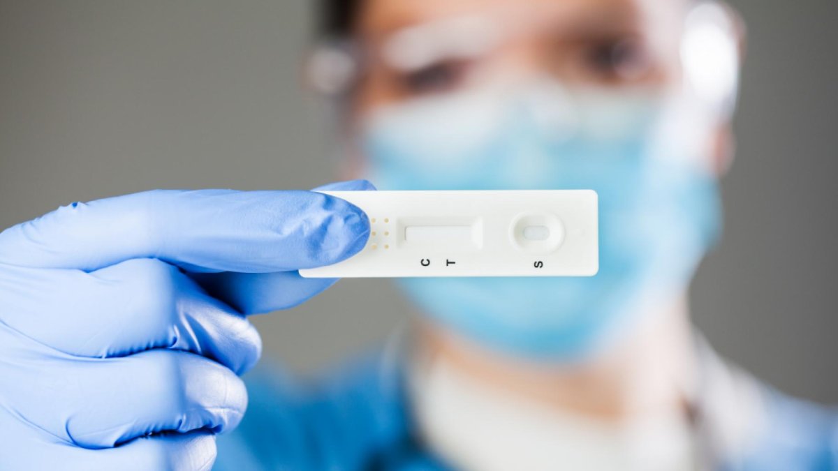 Un sanitario con un test de antígenos.