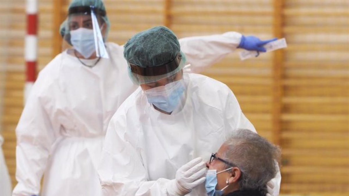 Una sanitaria toma muestras a una mujer.