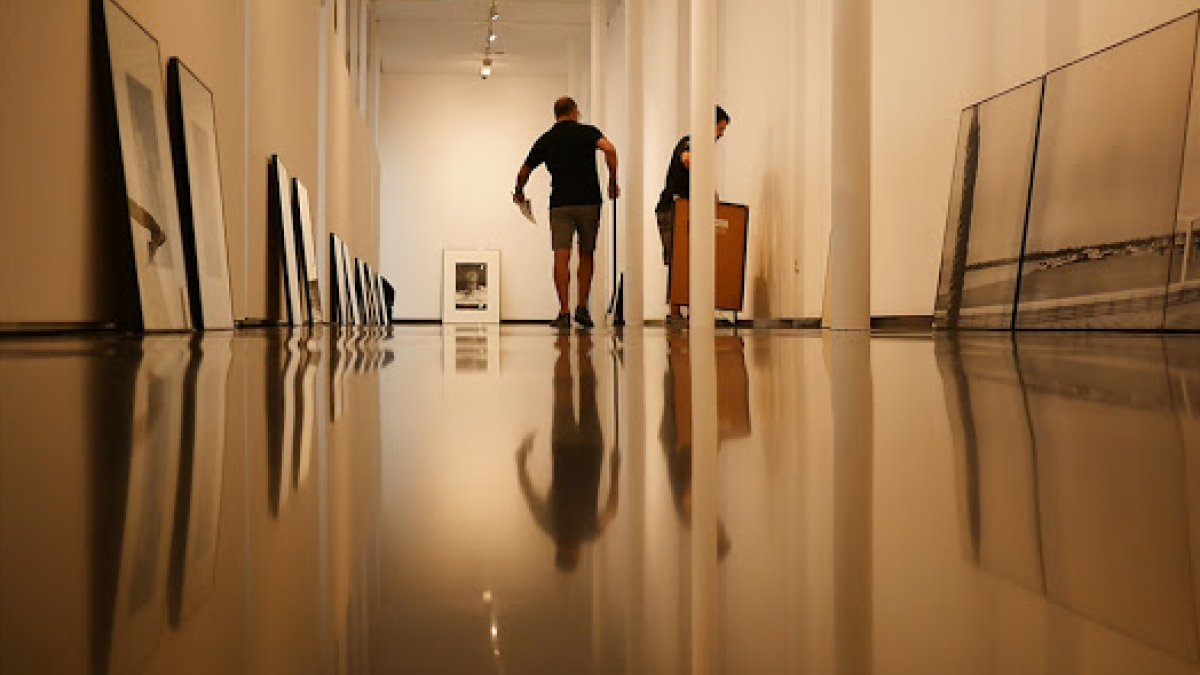 Operarios montan una exposición en el Centro Andaluz de Fotografía.