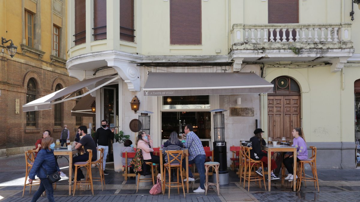 Varias personas disfrutan en la terraza de un bar de León.