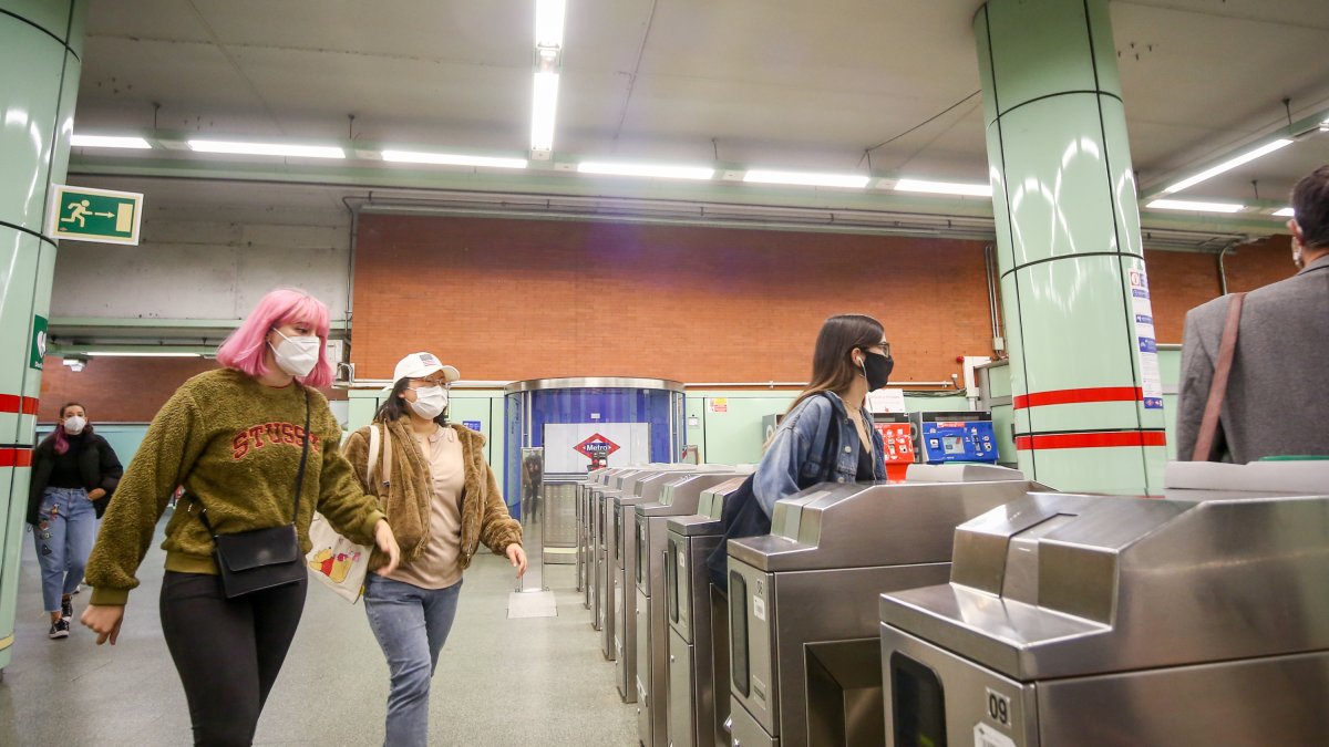 Varias personas pasan por los tornos de salida del Metro.