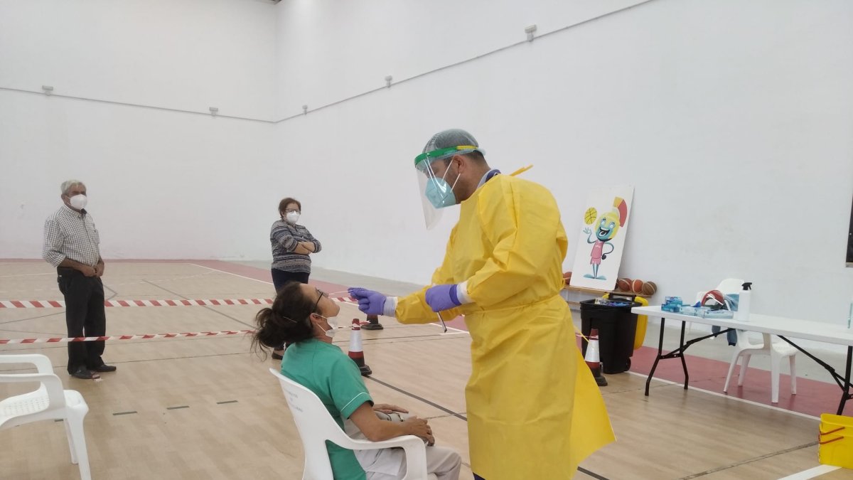 Un sanitario toma muestras nasales de una de las personas convocadas para realizarse las pruebas de antígenos.