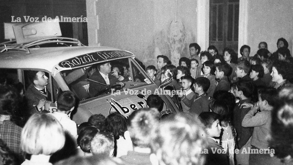 La furgoneta de Bazar Almería con sus altavoces colocados en la baca del techo, atravesando las calles de la ciudad ante una multitud.