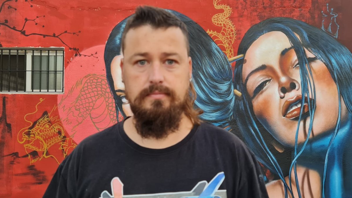 El artista urbano conocido como Nauni, delante de una de sus creaciones.