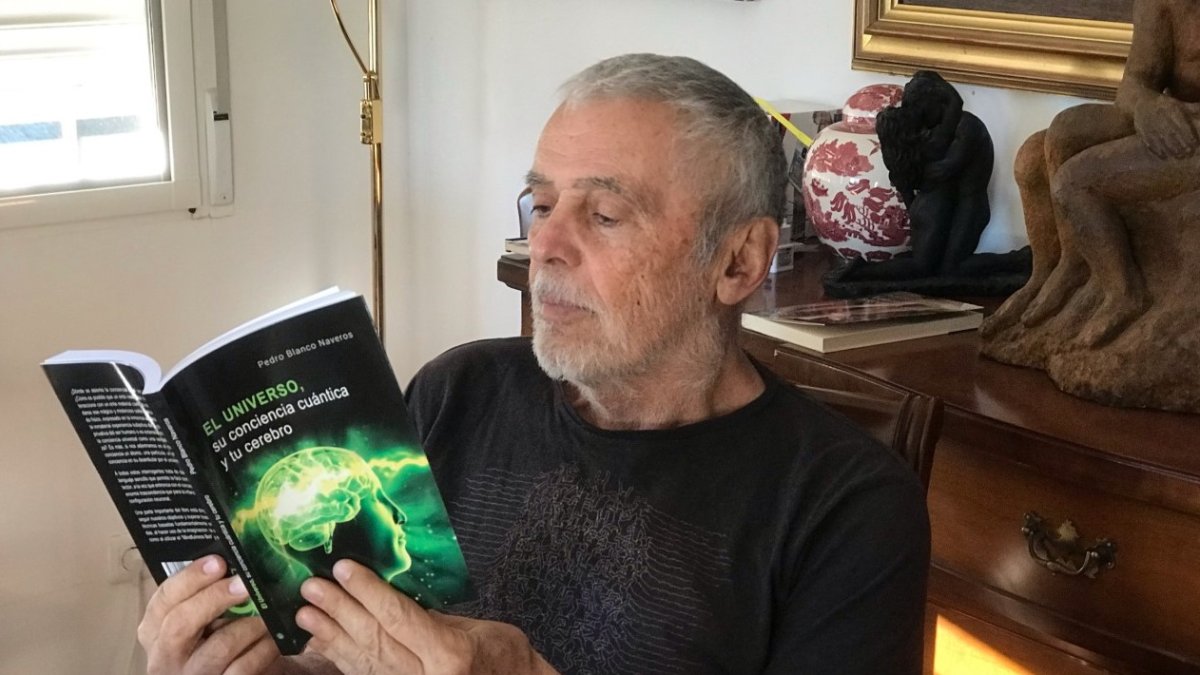 Pedro Blanco Naveros lee un ejemplar de su último libro sobre el universo.