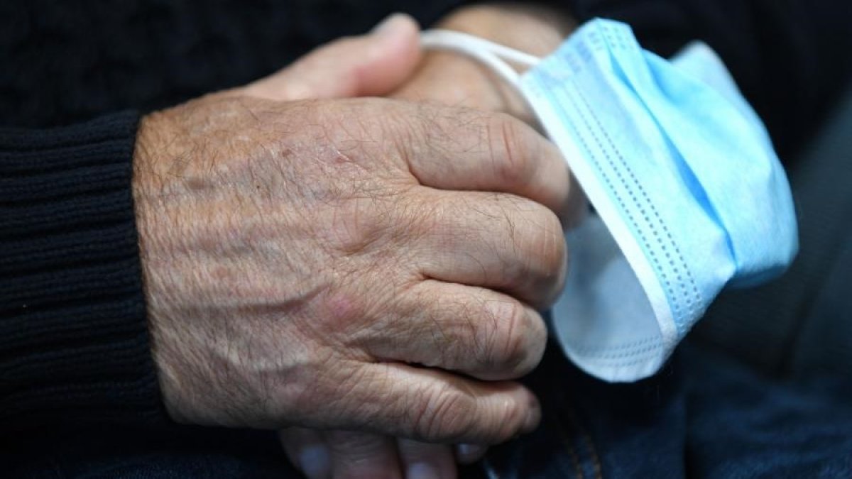 Un mayor con una mascarilla quirúrgica entre sus manos.