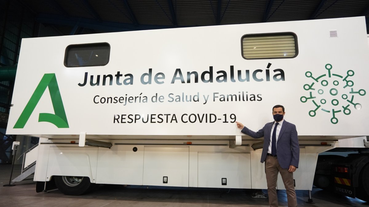 Juanma Moreno frente a una de las unidades móviles para cribados masivos.