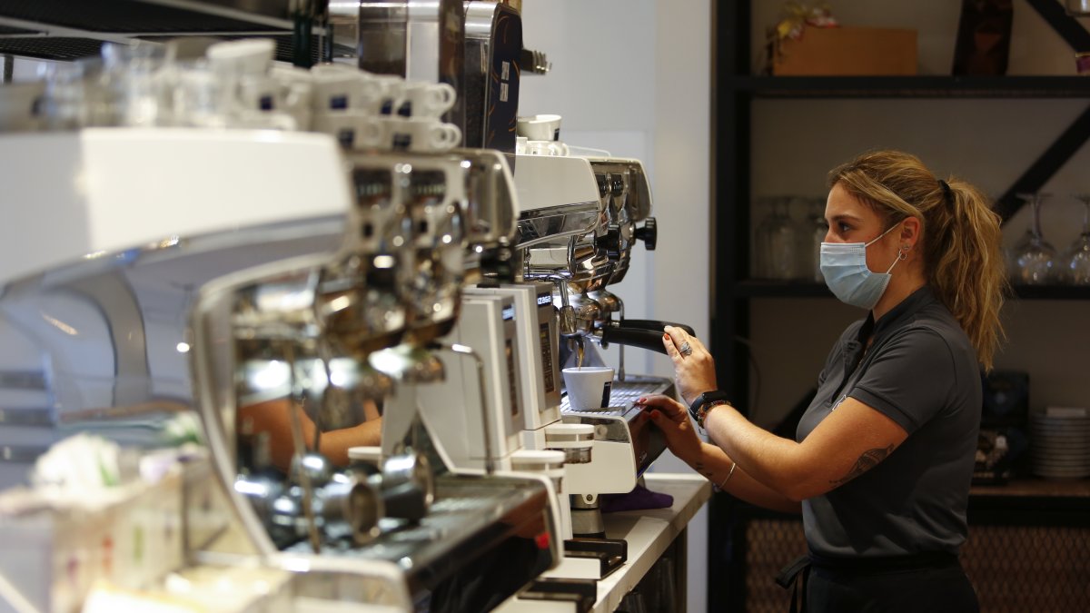 Una camarera sirviendo café en un bar de Granada.