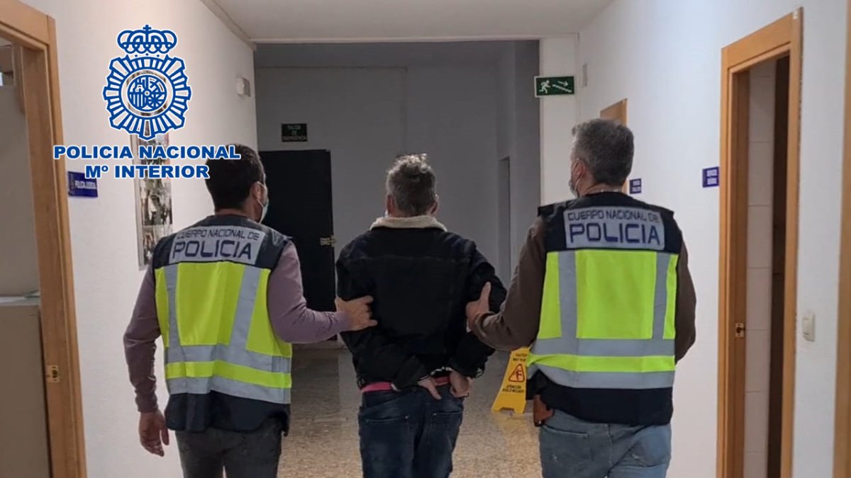 Dos agentes de la Policía Nacional, con uno de los detenidos.