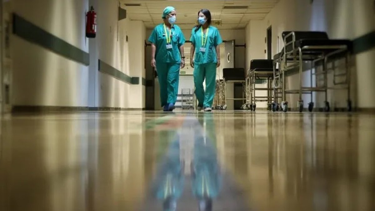 Dos sanitarios recorren un pasillo.