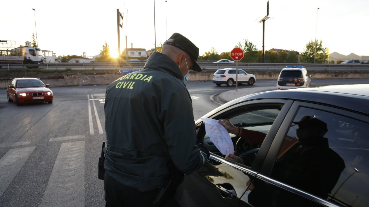 Un agente de la Guardia Civil comprueba el salvoconducto de un ciudadano.