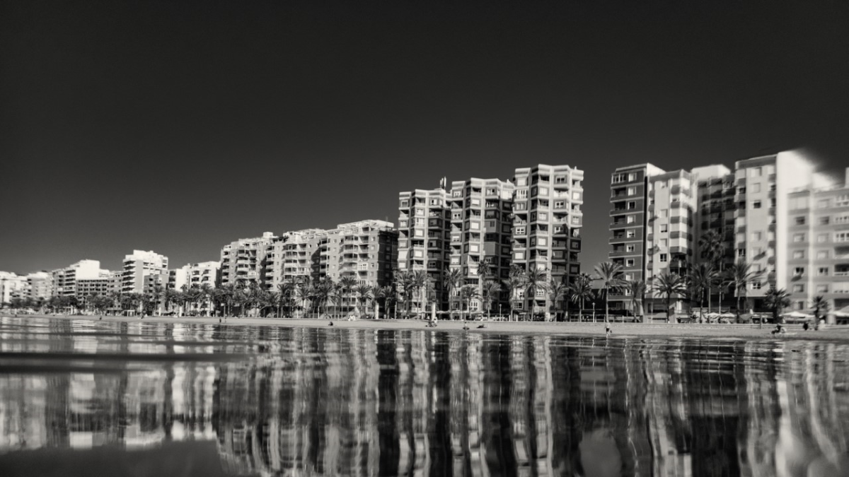 Los edificios del Paseo Marítimo de Almería reflejados sobre la playa. De la serie Entre olas del fotógrafo madrileño.