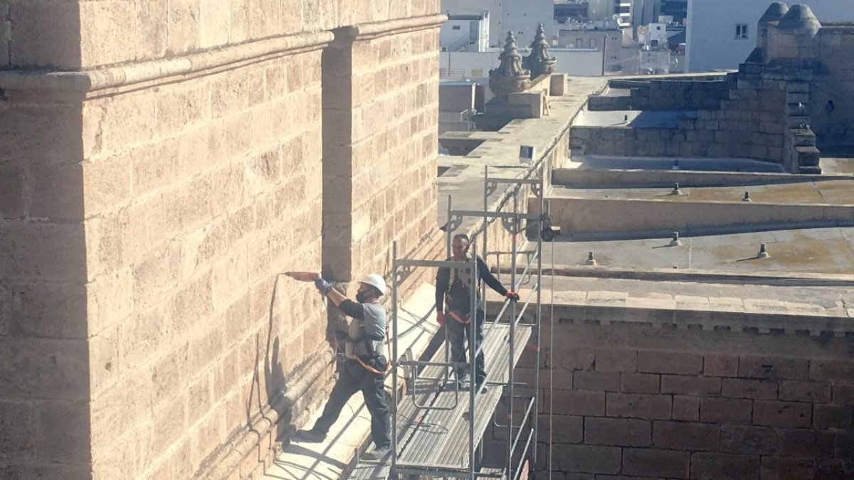 Un operario realizando hace unos días un agujero con taladro en la piedra caliza del campanario.