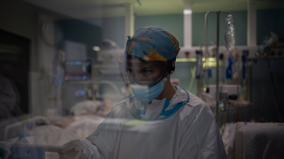 Una sanitaria en el interior de una habitación de paciente covid.