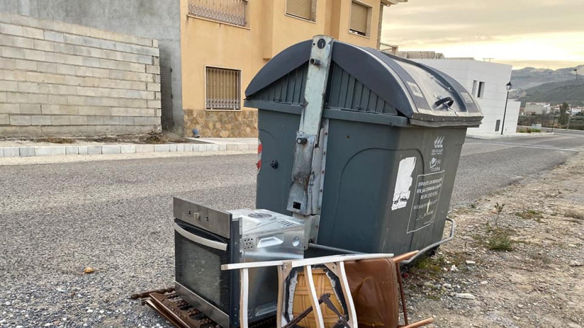 Enseres abandonados junto a un contenedor en Olula del Río.