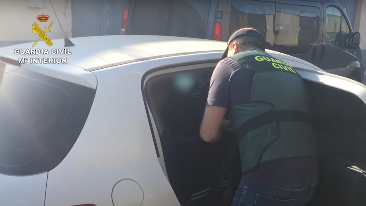 Un agente introduce a un acusado en el coche