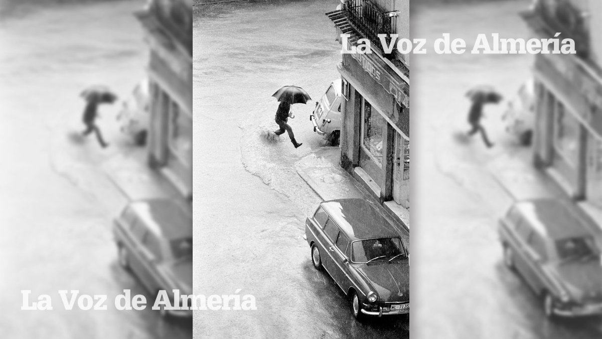 Un peatón intentando saltar por encima de un charco en la esquina entre la Plaza de Manuel Pérez y la Plaza del Carmen, frente al kiosco de Amalia.